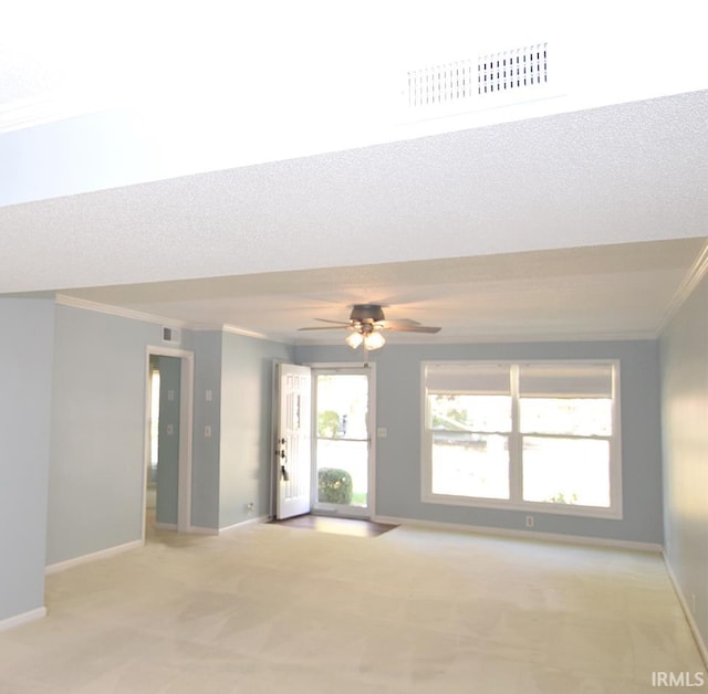 carpeted empty room with ceiling fan, a textured ceiling, and ornamental molding