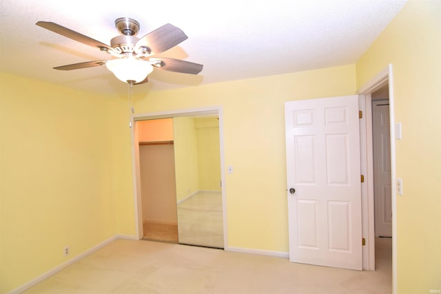 unfurnished bedroom with a closet, ceiling fan, a textured ceiling, and light colored carpet