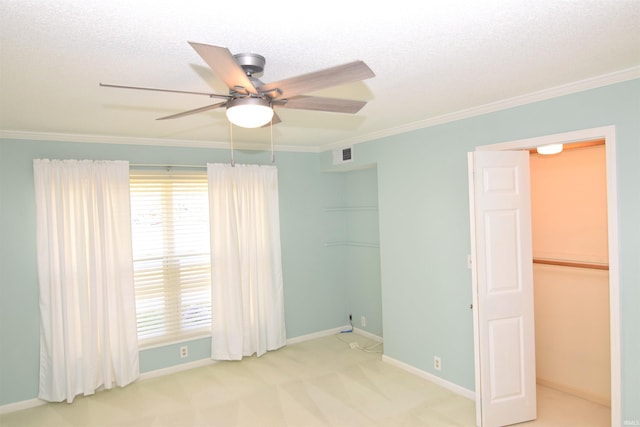 spare room with crown molding, carpet floors, a textured ceiling, and ceiling fan