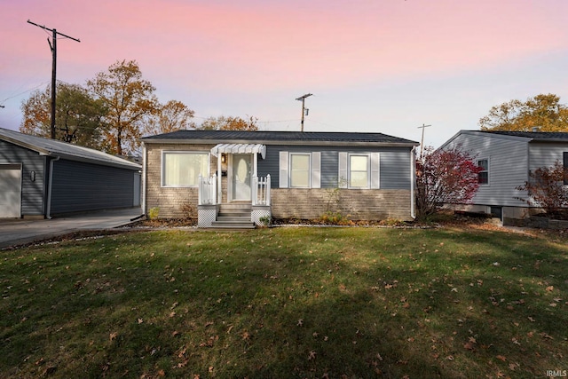 view of front of home featuring an outdoor structure, a garage, and a lawn