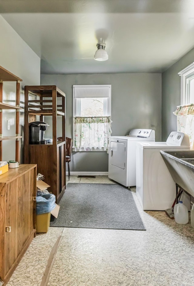 laundry room with light carpet, washing machine and dryer, and a wealth of natural light