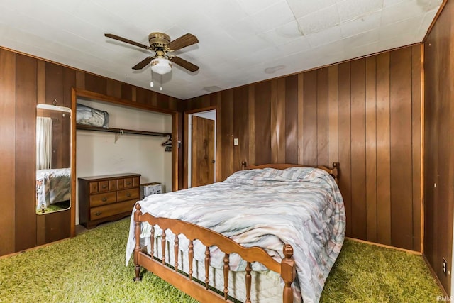 bedroom featuring wooden walls, carpet, and ceiling fan