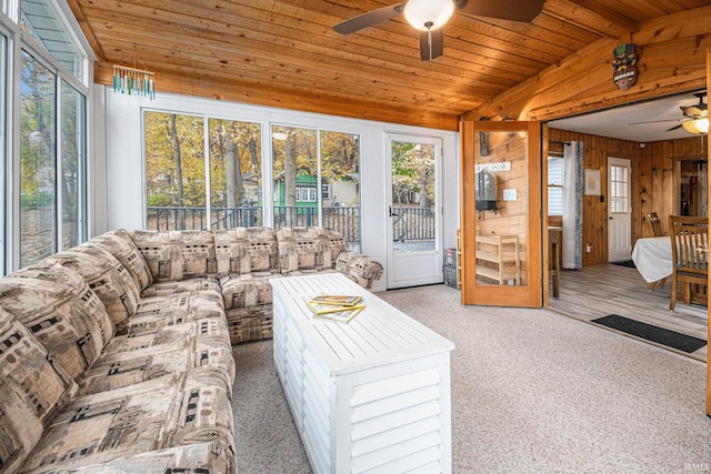 living room with wood ceiling, carpet, wooden walls, and ceiling fan