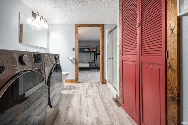 laundry area featuring a textured ceiling, hardwood / wood-style floors, and washer and clothes dryer