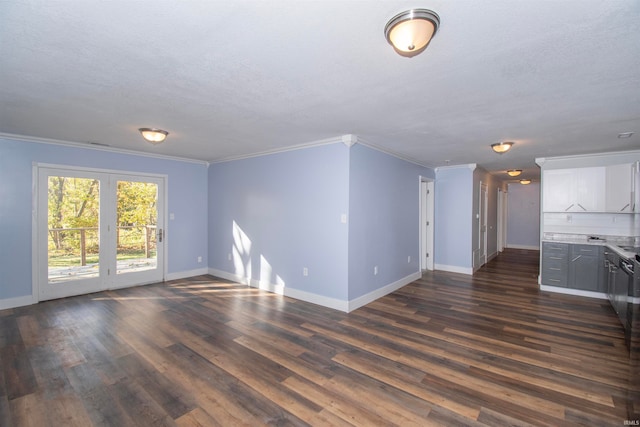 unfurnished living room with dark wood-type flooring, ornamental molding, and a textured ceiling