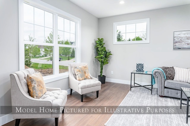 sitting room with hardwood / wood-style flooring and a healthy amount of sunlight