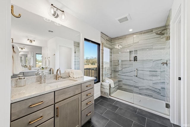 bathroom with vanity, a shower with door, tile patterned flooring, and a wealth of natural light