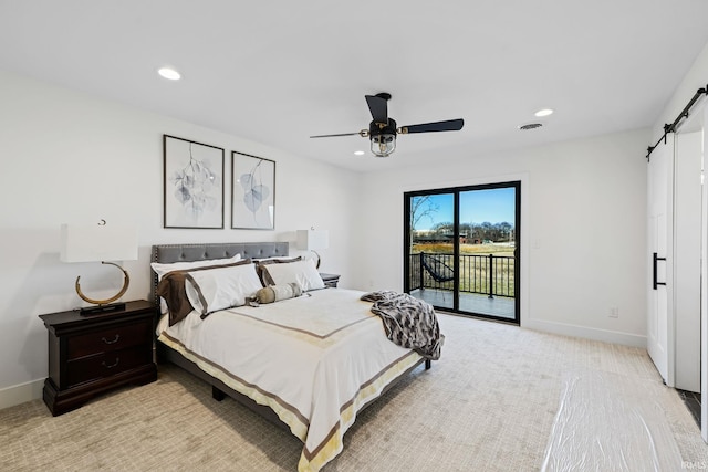 bedroom with a barn door, access to exterior, light colored carpet, and ceiling fan