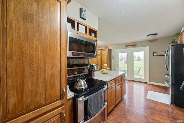 kitchen with appliances with stainless steel finishes and wood-type flooring