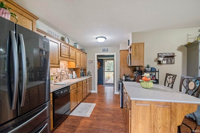 kitchen featuring decorative backsplash, a breakfast bar area, sink, black appliances, and dark hardwood / wood-style flooring