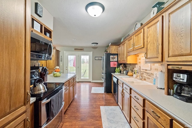 kitchen with tasteful backsplash, appliances with stainless steel finishes, sink, a textured ceiling, and dark hardwood / wood-style flooring