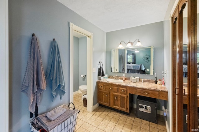 bathroom with vanity, toilet, and tile patterned flooring