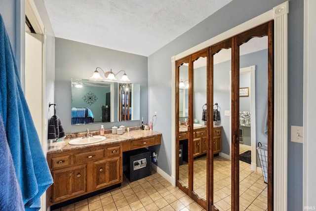 bathroom with vanity, a textured ceiling, and tile patterned floors