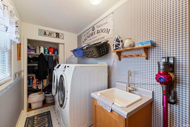 washroom featuring sink, a textured ceiling, washing machine and clothes dryer, and tile patterned floors