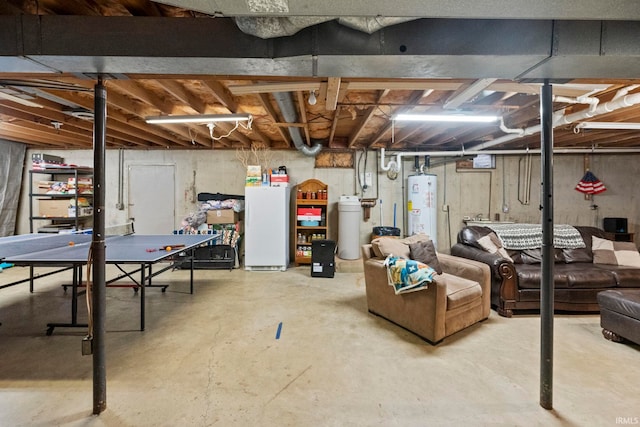 basement featuring gas water heater and white refrigerator