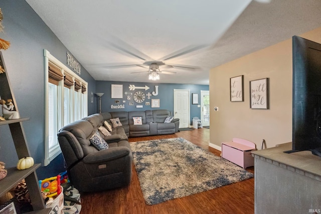 living room with dark wood-type flooring and ceiling fan