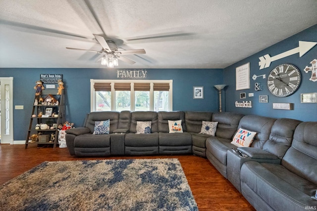 living room with a textured ceiling, ceiling fan, and dark hardwood / wood-style flooring