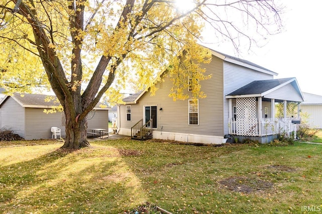 rear view of house featuring a yard