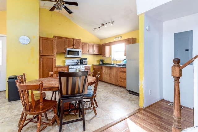 kitchen featuring ceiling fan, vaulted ceiling, light hardwood / wood-style floors, sink, and white appliances