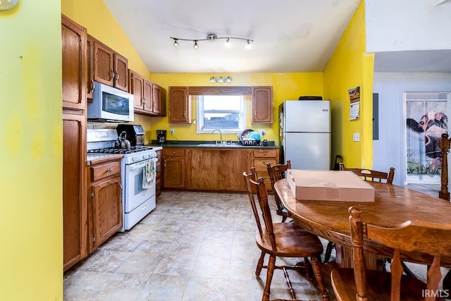 kitchen featuring sink, vaulted ceiling, and white appliances