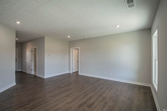 unfurnished room featuring a textured ceiling and dark hardwood / wood-style flooring