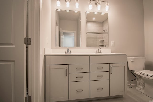 bathroom featuring toilet, vanity, and a shower with door