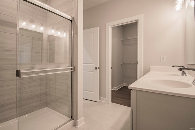 bathroom with vanity, tile patterned flooring, and a shower with door