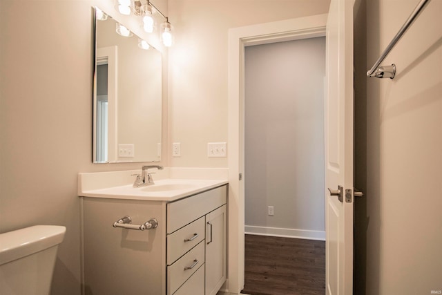 bathroom featuring vanity, wood-type flooring, and toilet