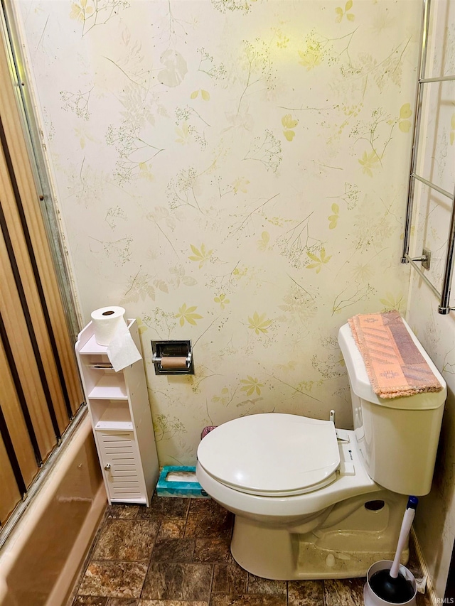 bathroom with bath / shower combo with glass door and toilet