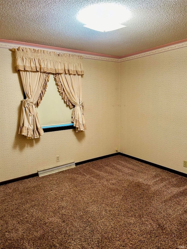 carpeted empty room with a textured ceiling