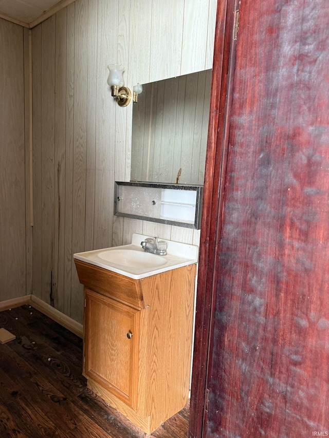 kitchen featuring wood walls, sink, and dark hardwood / wood-style floors