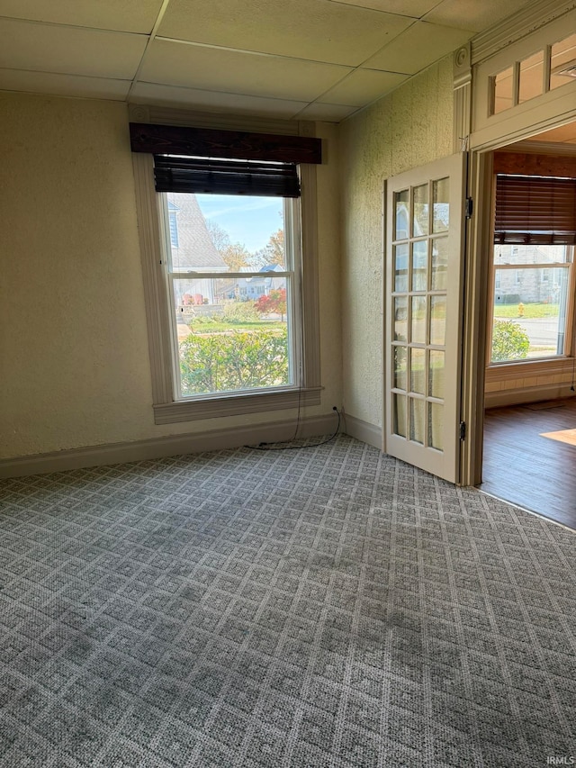 empty room with a drop ceiling and carpet floors