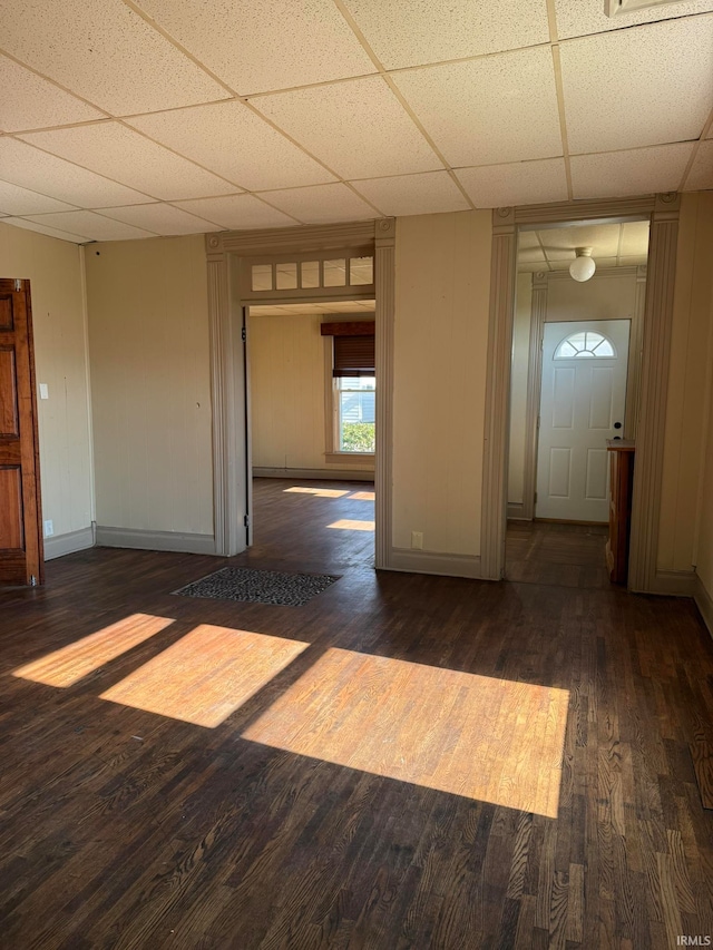 interior space featuring dark hardwood / wood-style flooring and a drop ceiling