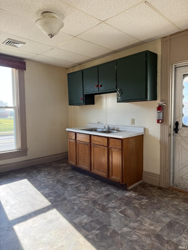 422 E Water St A-B, Unit A-B Portland, IN 47371 - kitchen featuring a sink, baseboards, plenty of natural light, brown cabinets, and a drop ceiling