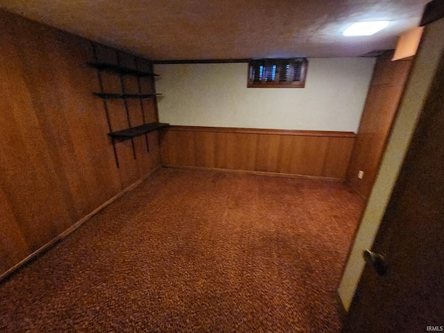 basement with carpet flooring and wooden walls