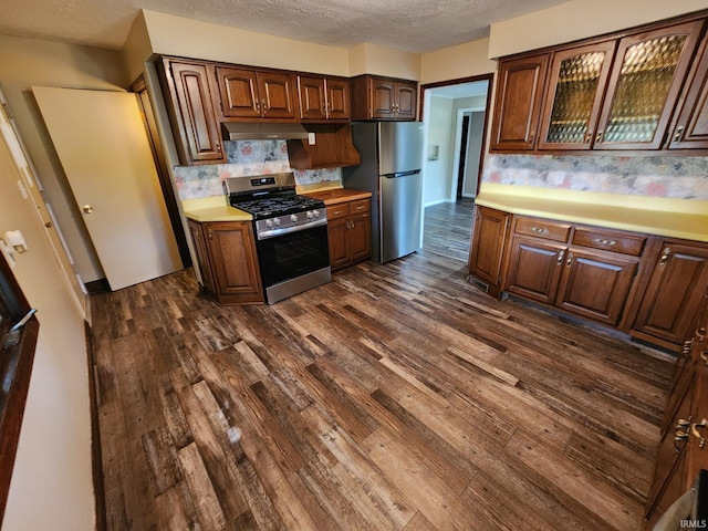 kitchen featuring decorative backsplash, a textured ceiling, dark hardwood / wood-style flooring, and stainless steel appliances