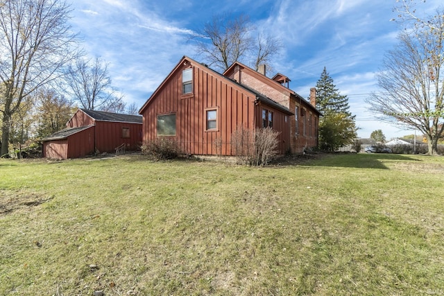 8126 Coldwater Rd, Fort Wayne, IN 46825 - view of side of home featuring board and batten siding, a yard, and a chimney