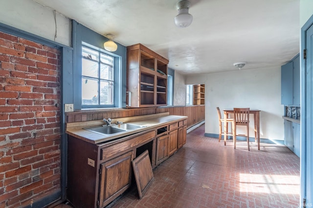 kitchen with brick wall, sink, and a breakfast bar