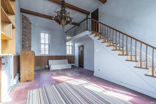 8126 Coldwater Rd, Fort Wayne, IN 46825 - unfurnished living room featuring a chandelier, beam ceiling, stairway, a high ceiling, and wood finished floors