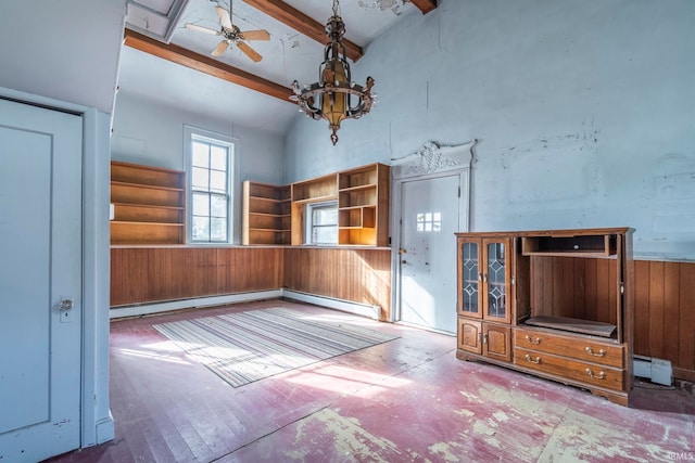 unfurnished living room with wood walls, a baseboard heating unit, hardwood / wood-style floors, ceiling fan, and beamed ceiling