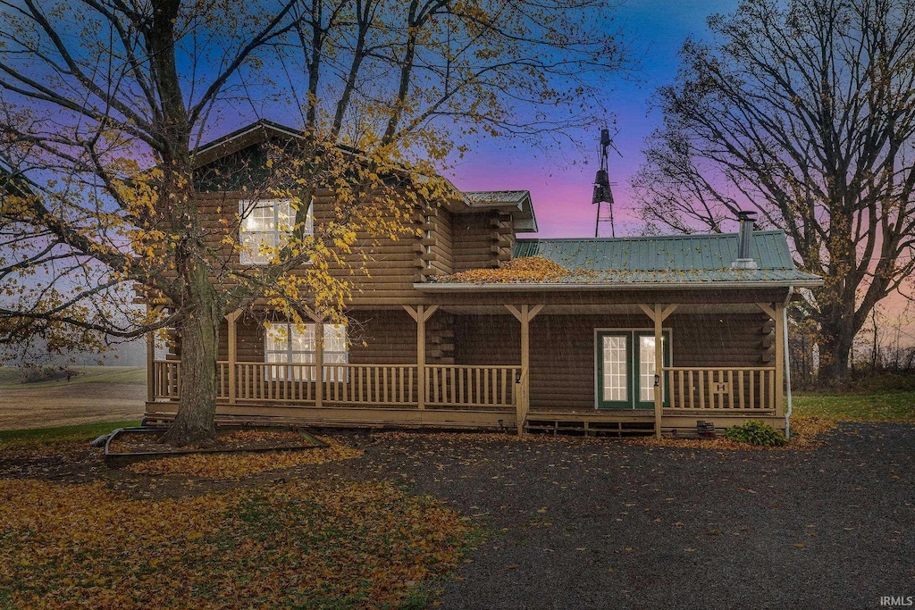 log home featuring covered porch