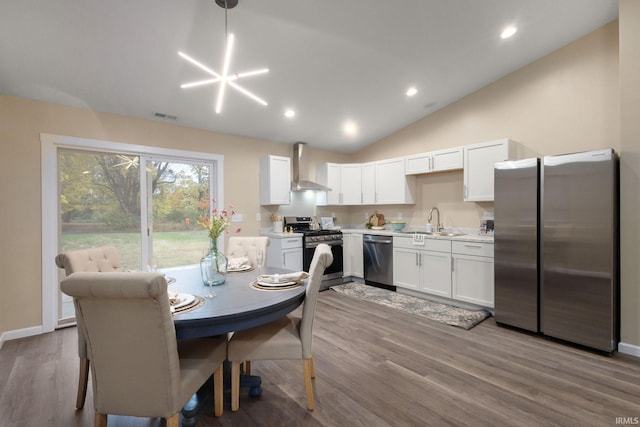 dining space with sink, vaulted ceiling, and light wood-type flooring