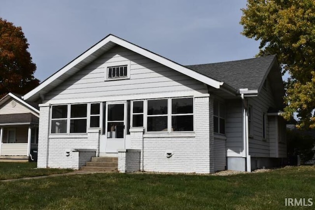 view of front of property featuring a front lawn and a sunroom