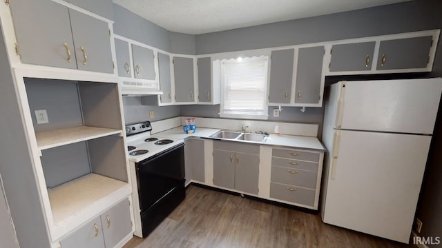 kitchen featuring dark hardwood / wood-style flooring, extractor fan, a textured ceiling, sink, and white appliances