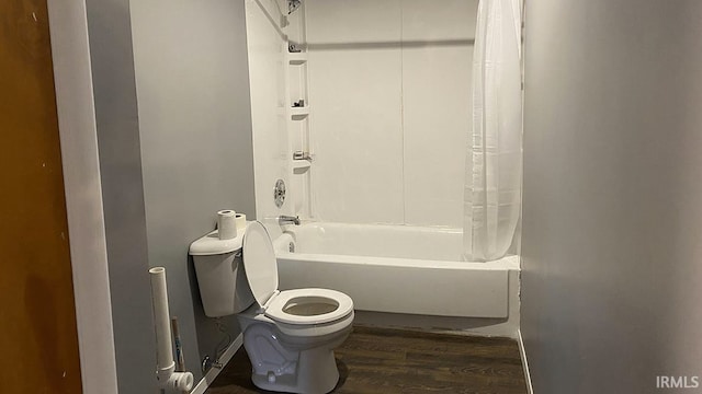 bathroom featuring toilet, hardwood / wood-style floors, and shower / bath combination with curtain