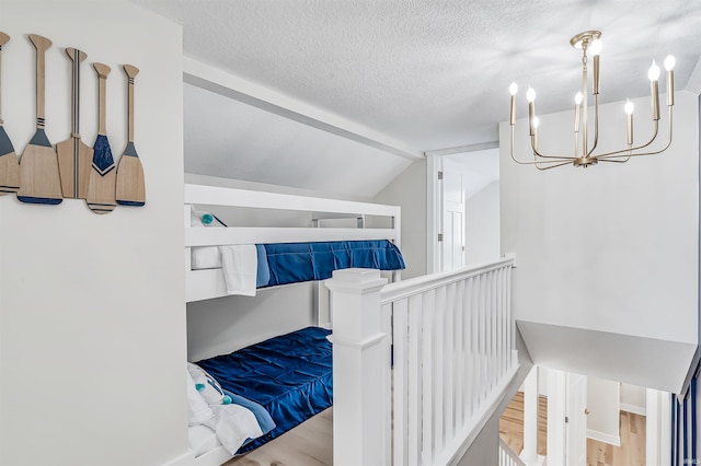 interior space featuring hardwood / wood-style floors, a textured ceiling, and vaulted ceiling