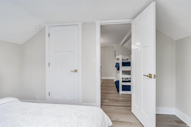 bedroom featuring vaulted ceiling and light wood-type flooring