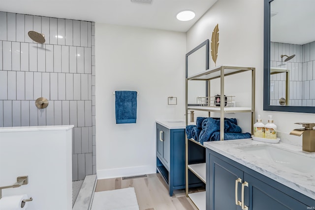 bathroom with vanity, hardwood / wood-style floors, and walk in shower