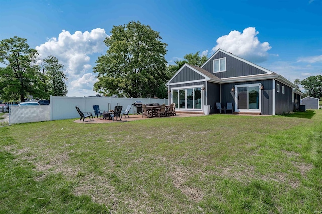 back of house with a patio, a fire pit, and a yard