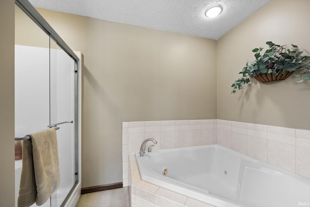 bathroom with a textured ceiling and shower with separate bathtub